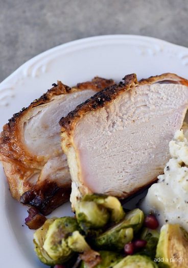 Photo of turkey slices, brussels sprouts and mashed potatoes on a white plate.