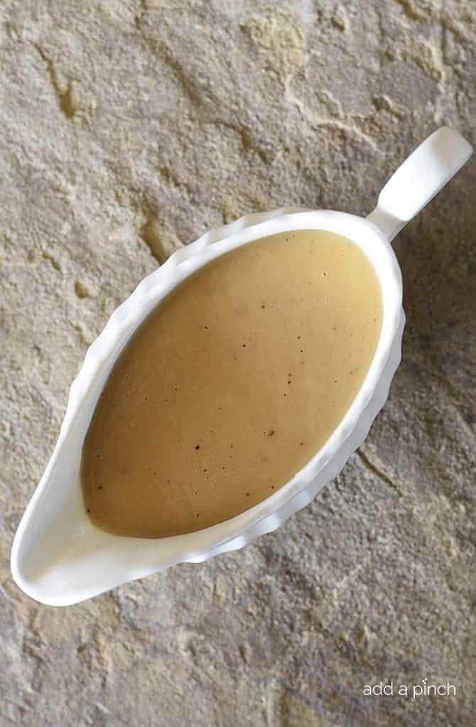 Turkey Gravy in a white stoneware gravy boat on a stone background  // addapinch.com