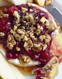 Warm Brie with Honeyed Fruit Compote makes a beautiful, quick and easy appetizer. Made with a honeyed cranberry walnut fruit compote, this warm brie recipe is festive for the holidays! // addapinch.com