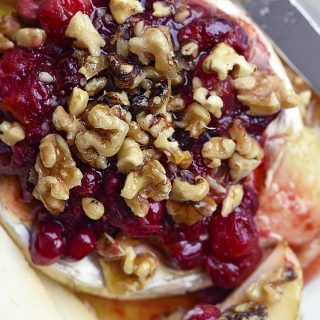 Warm Brie with Honeyed Fruit Compote makes a beautiful, quick and easy appetizer. Made with a honeyed cranberry walnut fruit compote, this warm brie recipe is festive for the holidays! // addapinch.com