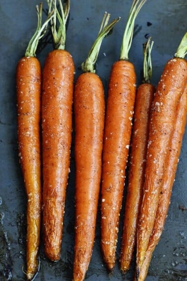 Photo of Garlic Roasted Carrots on gray background.