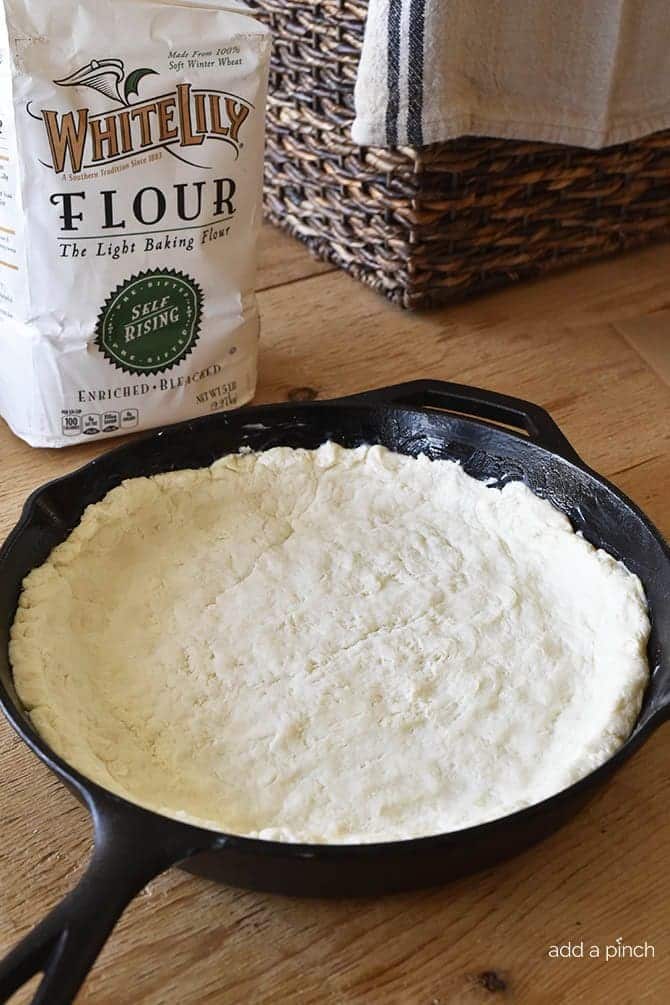 Cream Biscuit recipe for the crust is placed into iron skillet // addapinch.com