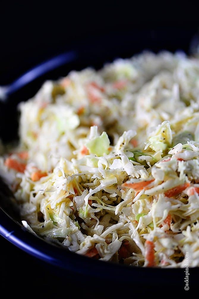 Blue bowl with shredded cabbage and carrots in coleslaw // addapinch.com