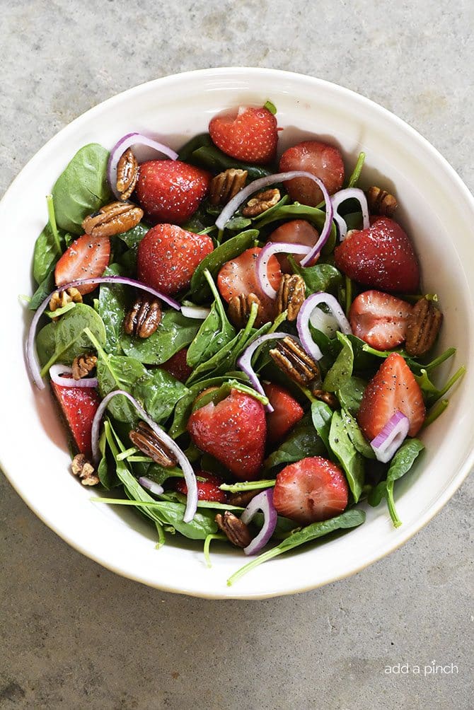 Strawberry Spinach Salad Recipe - Strawberry Spinach Salad topped with an easy Poppy Seed Dressing makes for a beautiful and delicious spring and summer salad recipe. Perfect for parties, picnics, and get-togethers! Always a crowd favorite.
