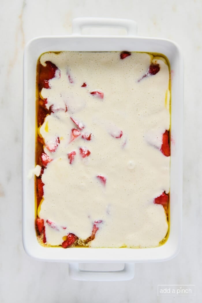 Unbaked strawberry cobbler in a white baking dish