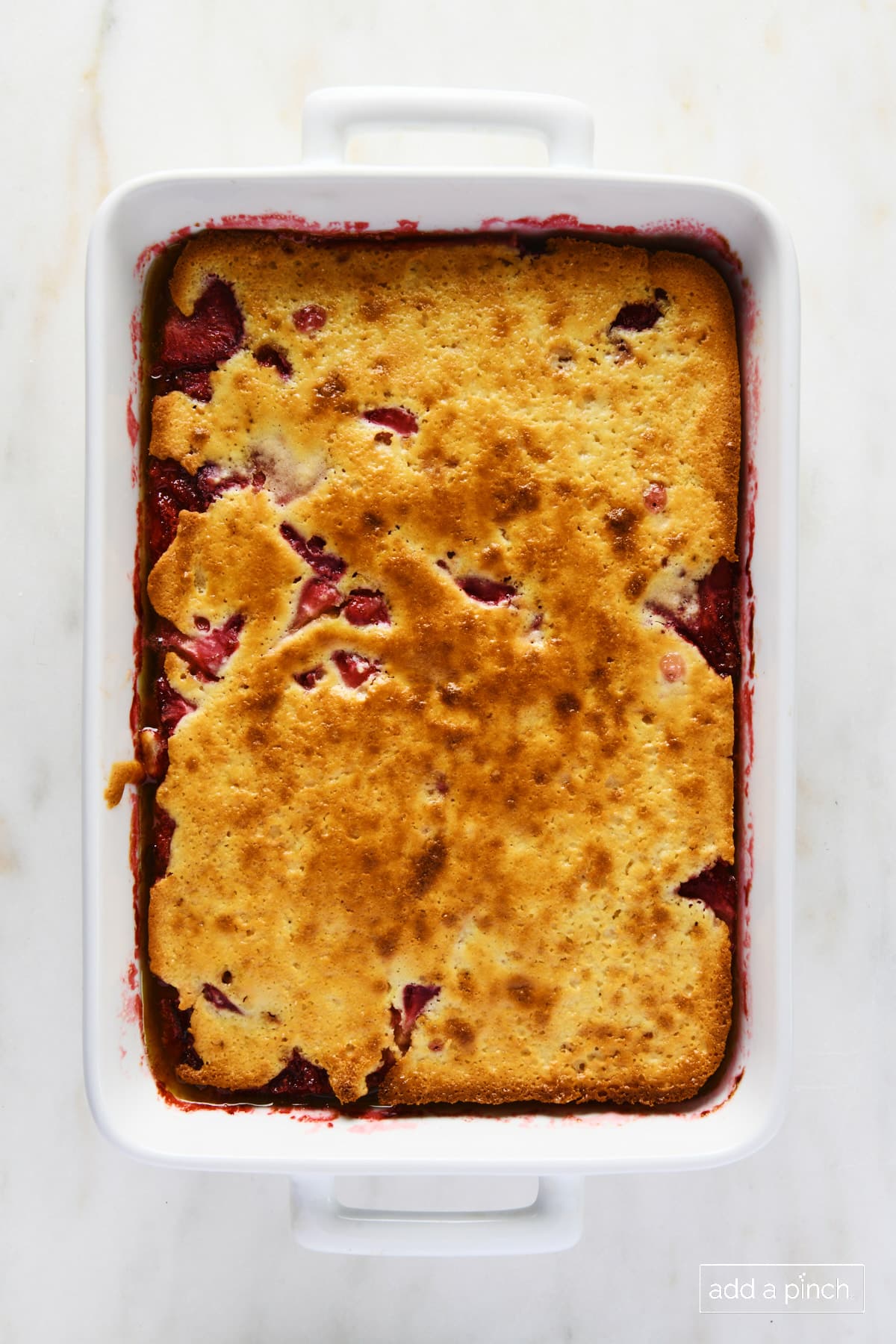 Baked strawberry cobbler in a white baking dish