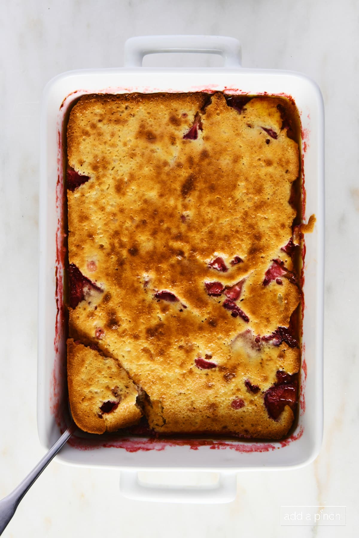 Strawberry cobbler in a white baking dish ready to be served