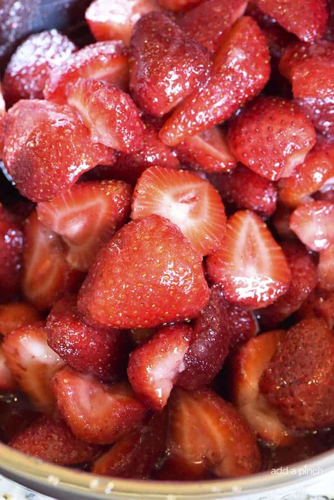 Bowl of ripe strawberries that have been tossed with a small amount of sugar // addapinch.com