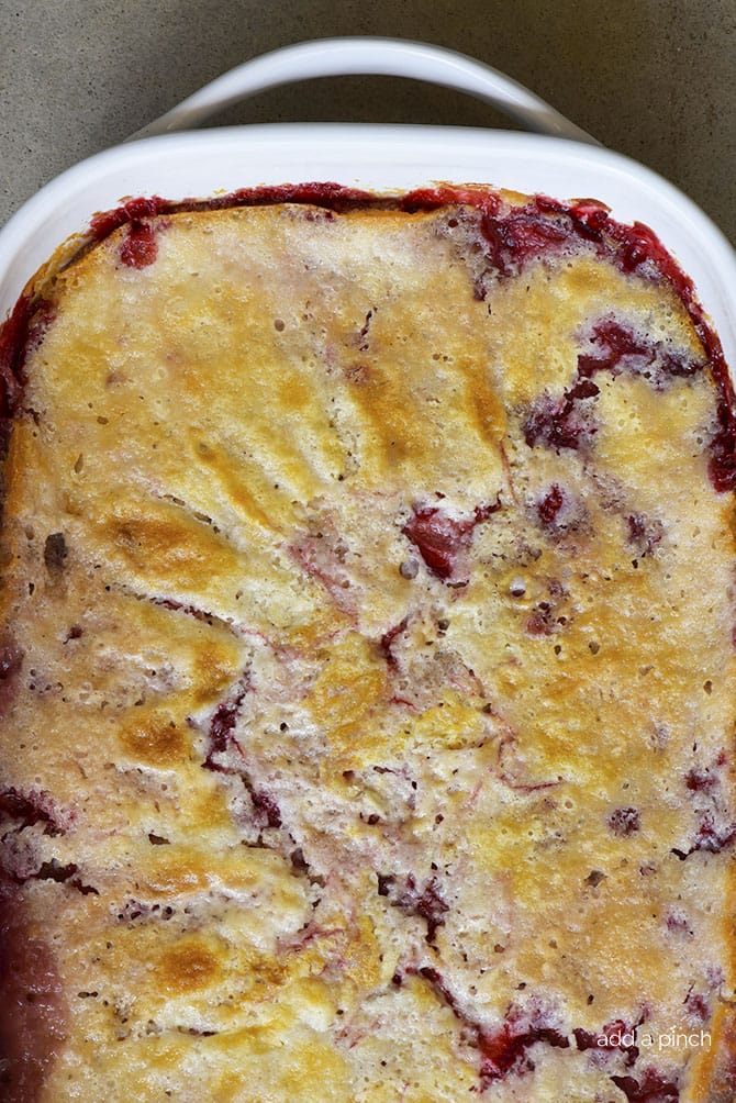 Strawberry Cobbler with golden brown crust in white baking dish // addapinch.com