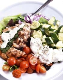 Grilled Chicken Salad with Pesto Ranch Dressing Recipe makes a delicious salad with cucumbers, tomatoes, onion, mozzarella topped with grilled chicken and a pesto ranch dressing! // addapinch.com