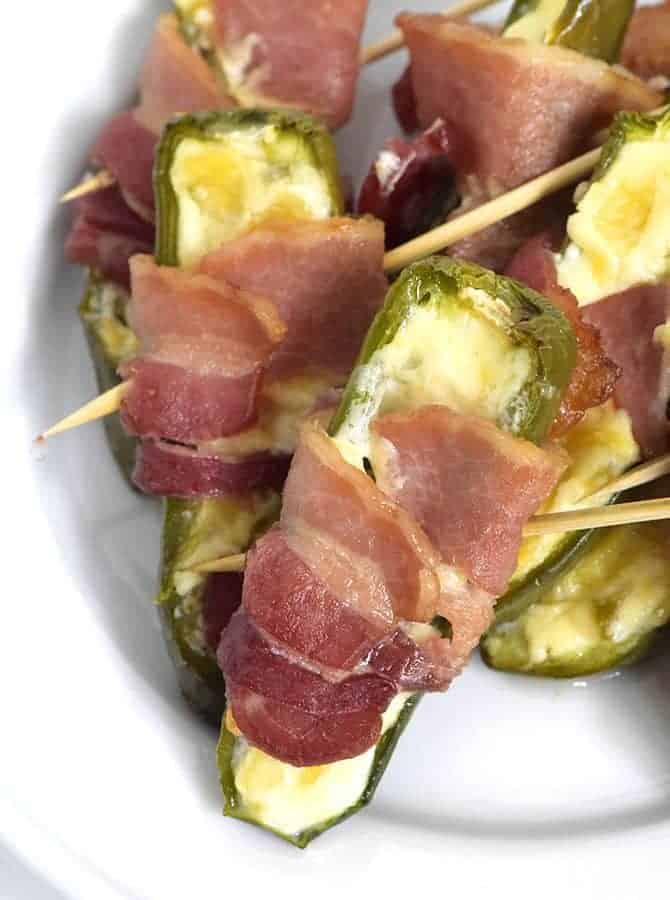 Pineapple Jalapeno Popper Recipe - Sweet and spicy, these jalapeno poppers are made with a pineapple cream cheese spread, wrapped with bacon and baked to perfection! // addapinch.com