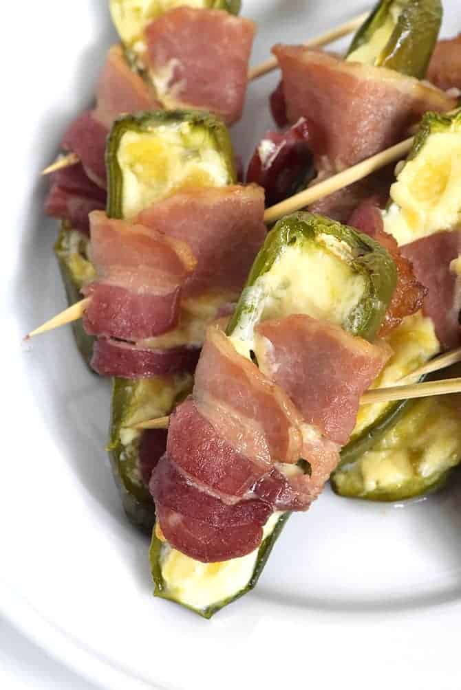 Pineapple Jalapeno Popper Recipe - Sweet and spicy, these jalapeno poppers are made with a pineapple cream cheese spread, wrapped with bacon and baked to perfection! // addapinch.com