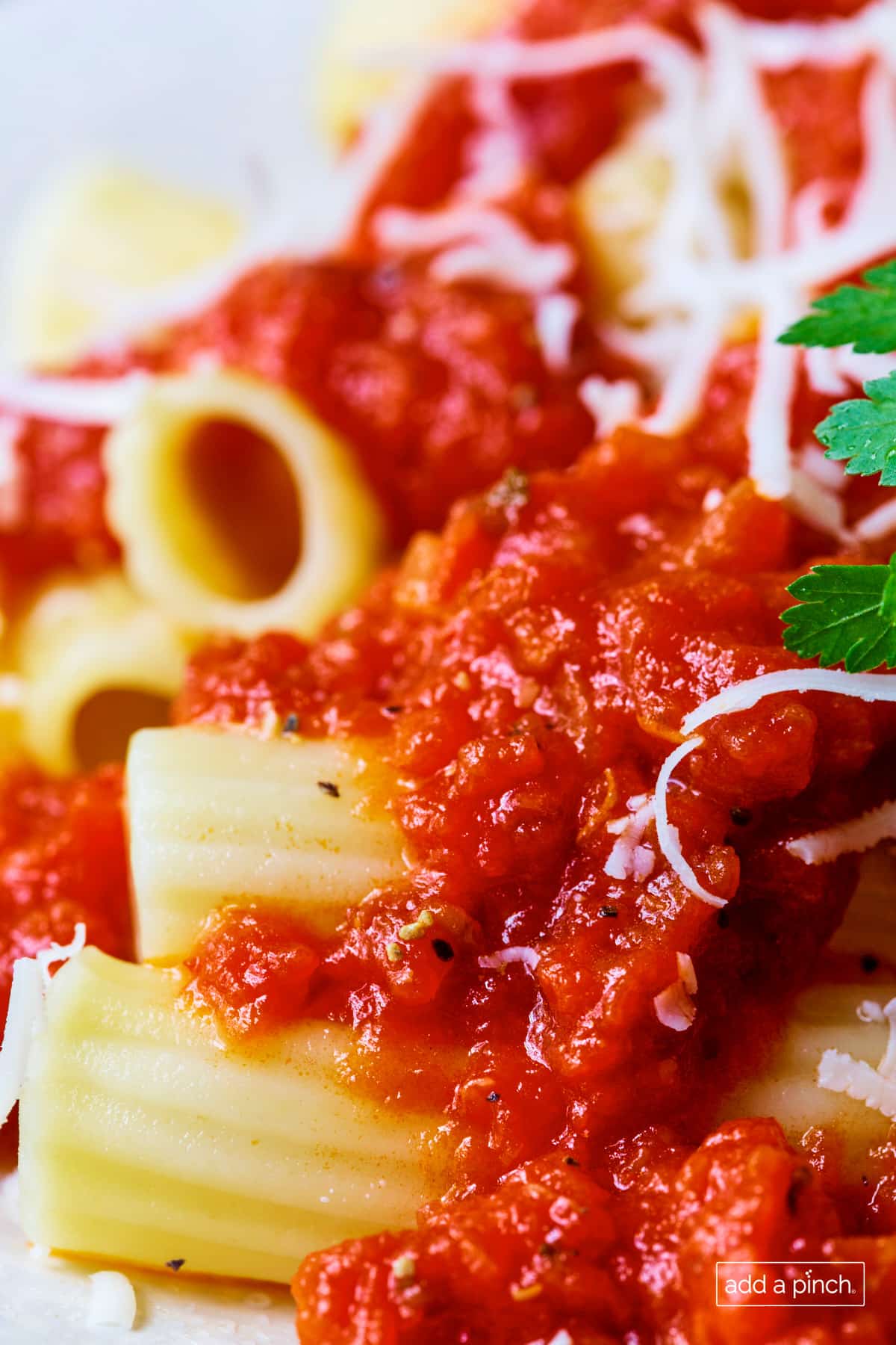 Easy marinara sauce over cooked pasta topped with parmesan and fresh herbs.