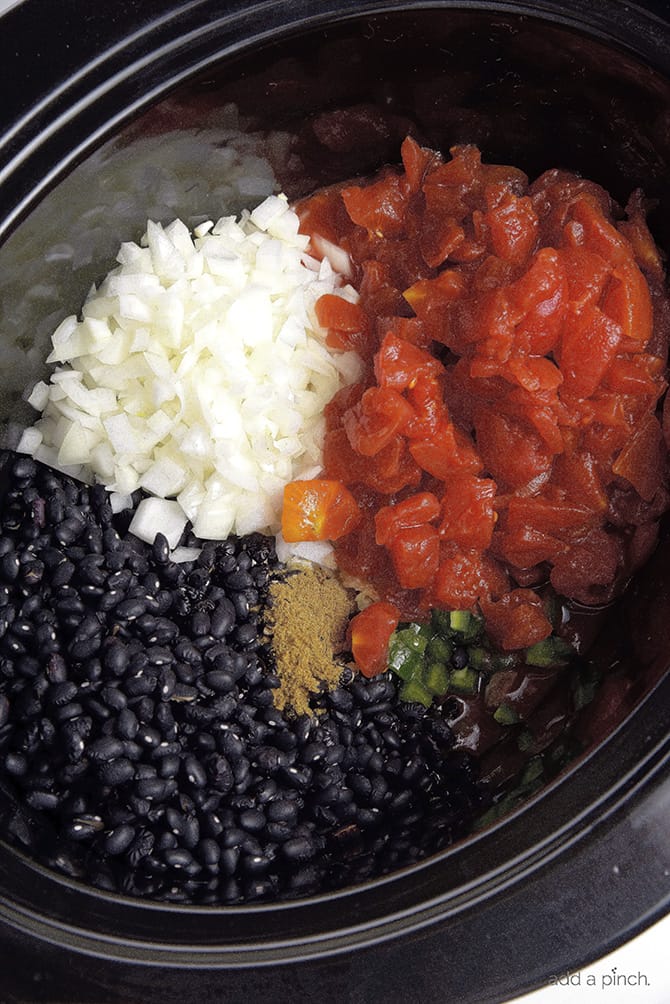 Ingredients for Black Bean Soup Recipe added to the slow cooker insert // addapinch.com