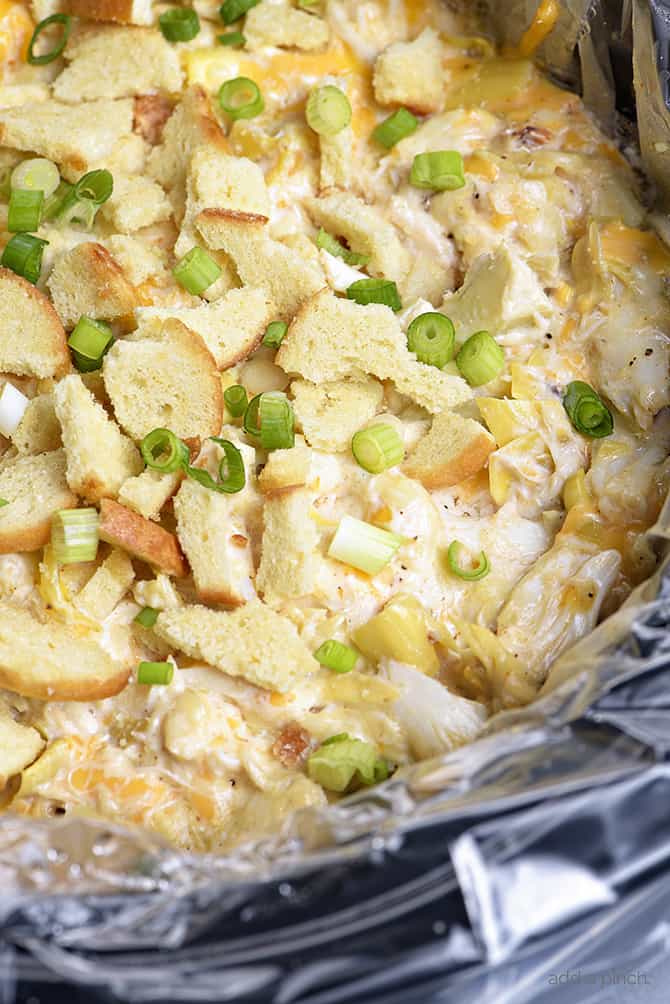 Slow Cooker Hot Crab Artichoke Dip Recipe - A delicious hot crab artichoke dip recipe made even easier with the slow cooker! Serve with butter crackers or toasted bagels! Always a party favorite! // addapinch.com