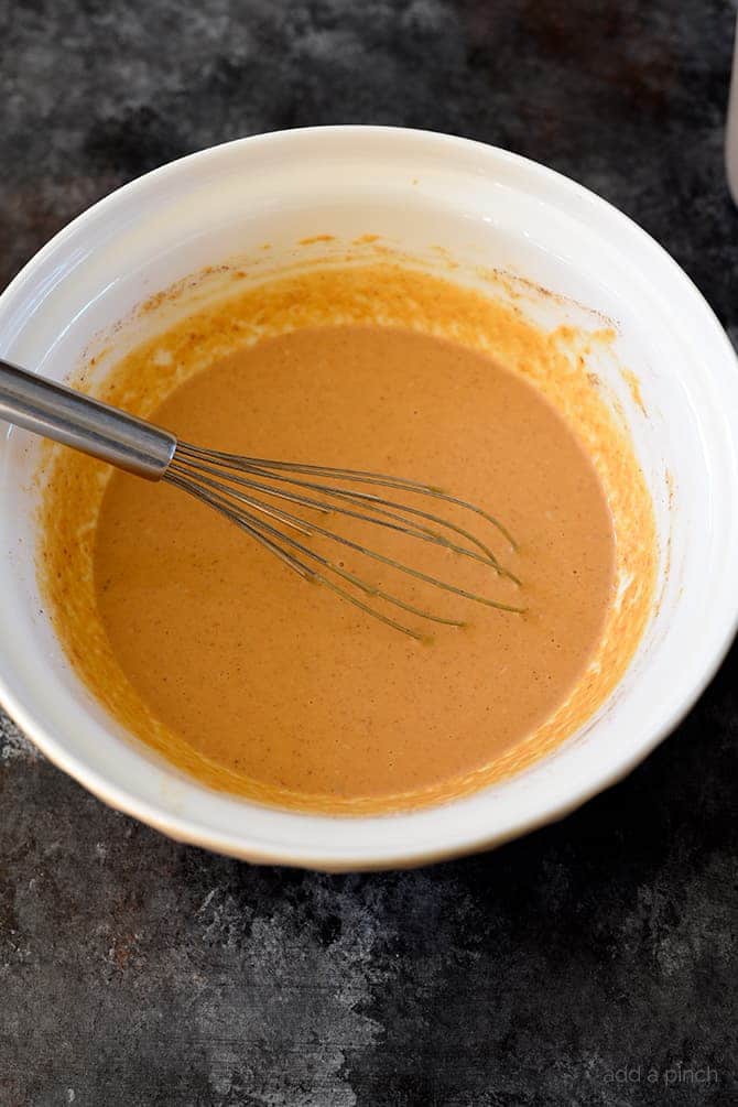 White bowl, whisk and pumpkin pudding. 