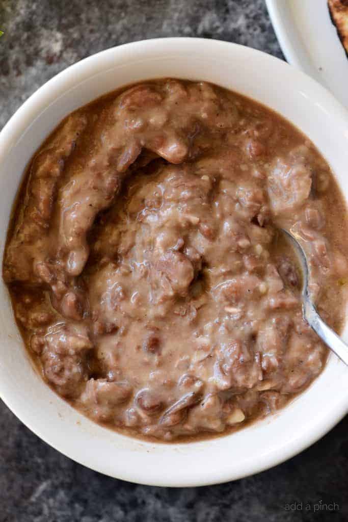Refried Beans Recipe - This quick and easy refried beans recipe made with pinto beans, onion, and spices makes a delicious side dish for so many meals! // addapinch.com