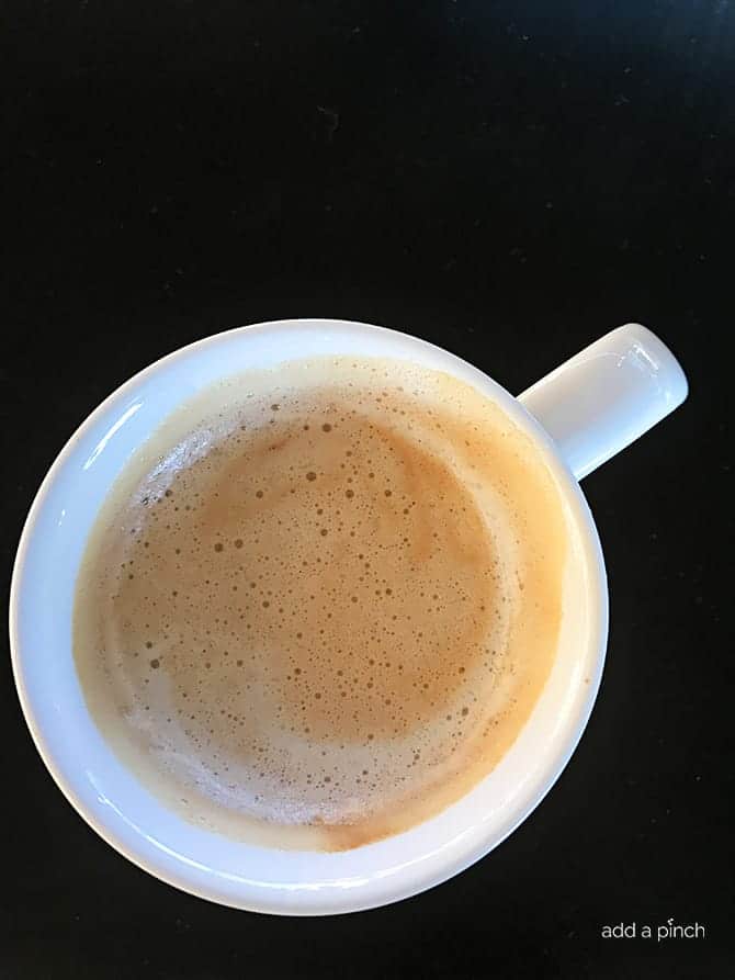 photograph of hot chocolate in a mug on a dark background.