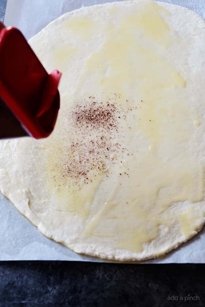 Rolled dough with melted butter and sprinkle of cinnamon // addapinch.com