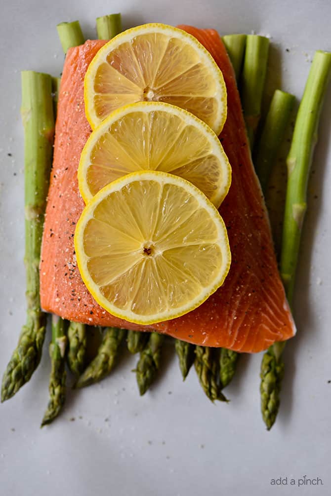 Lemon Garlic Salmon and Asparagus Parchment Packet Recipe - This quick and easy recipe comes together in a snap and is ready and on the table in 15 minutes! // addapinch.com