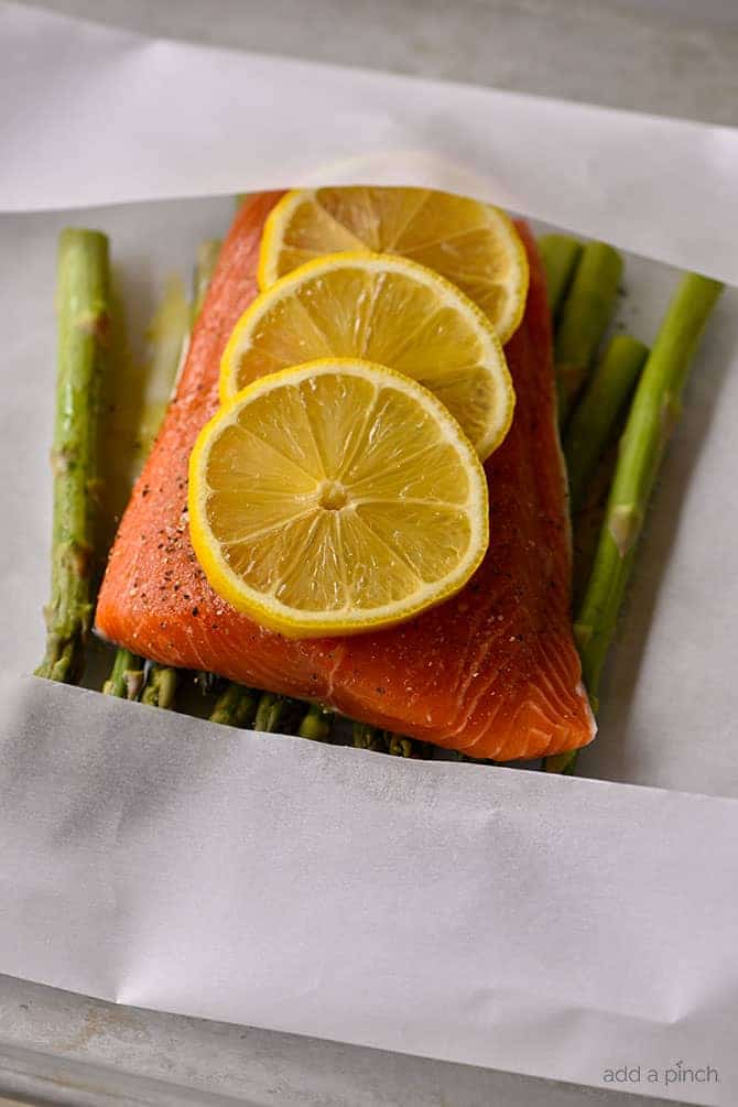 Lemon Garlic Salmon and Asparagus Parchment Packet Recipe - This quick and easy recipe comes together in a snap and is ready and on the table in 15 minutes! // addapinch.com