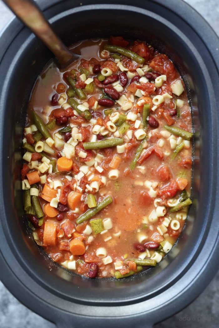 This savory Slow Cooker Minestrone Soup Recipe is full of seasonal vegetables and made even easier in this slow cooker recipe! A delicious family favorite! // addapinch.com