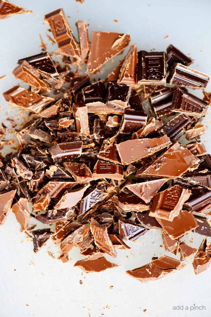 Photograph of chopped Hershey's chocolate bars on a white background. // addapinch.com
