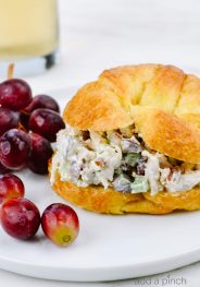 Chicken Salad on a croissant surrounded by red grapes // addapinch.com