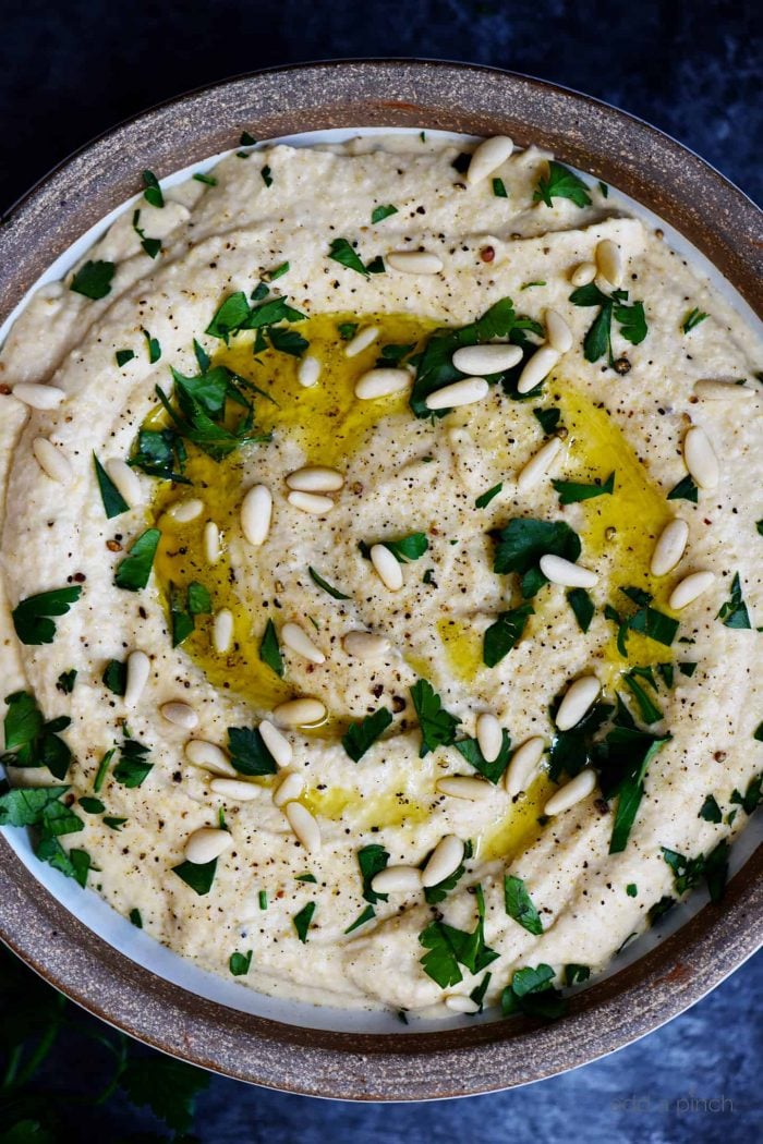 Hummus topped with pine nuts, olive oil and parsley  // addapinch.com