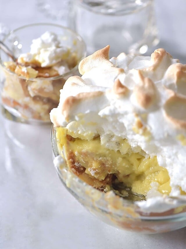 Photo of banana pudding with meringue topping on a white background.