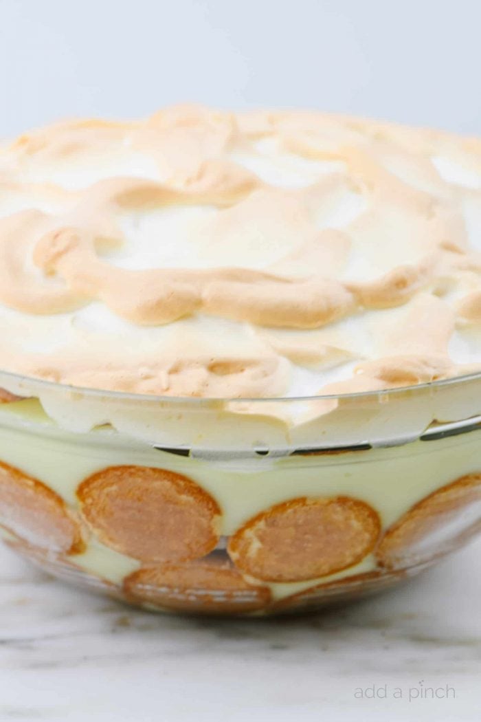 Browned edges on homemade meringue tops Southern Banana Pudding in a glass bowl lined with vanilla wafers // addapinch.com