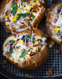 Air Fryer Enchilada Stuffed Baked Potatoes Recipe - This quick and easy recipe combines a perfect baked potato filled with black beans, enchilada sauce, and more! // addapinch.com