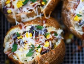 Air Fryer Enchilada Stuffed Baked Potatoes Recipe - This quick and easy recipe combines a perfect baked potato filled with black beans, enchilada sauce, and more! // addapinch.com