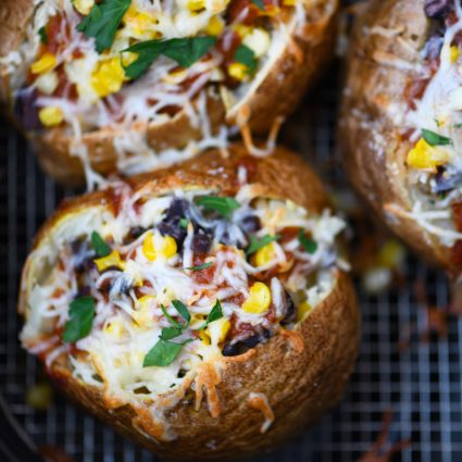 Air Fryer Enchilada Stuffed Baked Potatoes Recipe - This quick and easy recipe combines a perfect baked potato filled with black beans, enchilada sauce, and more! // addapinch.com