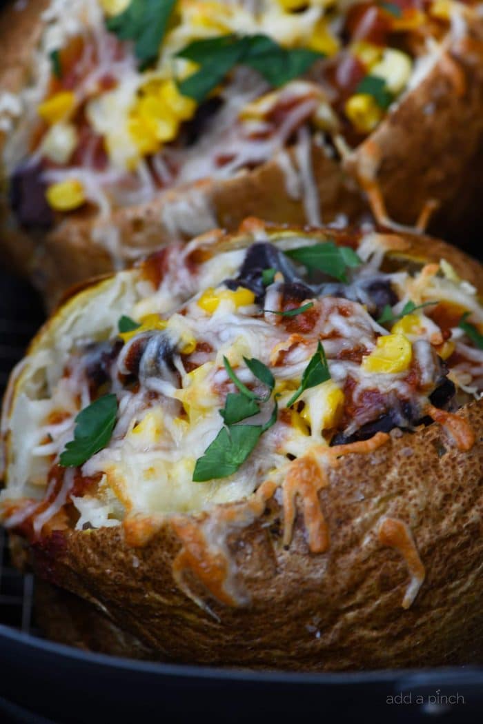 Air Fryer Enchilada Stuffed Baked Potatoes Recipe - This quick and easy recipe combines a perfect baked potato filled with black beans, enchilada sauce, and more! // addapinch.com