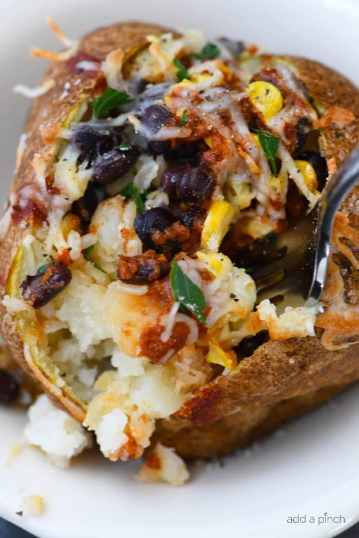 Air Fryer Enchilada Stuffed Baked Potatoes Recipe - This quick and easy recipe combines a perfect baked potato filled with black beans, enchilada sauce, and more! // addapinch.com