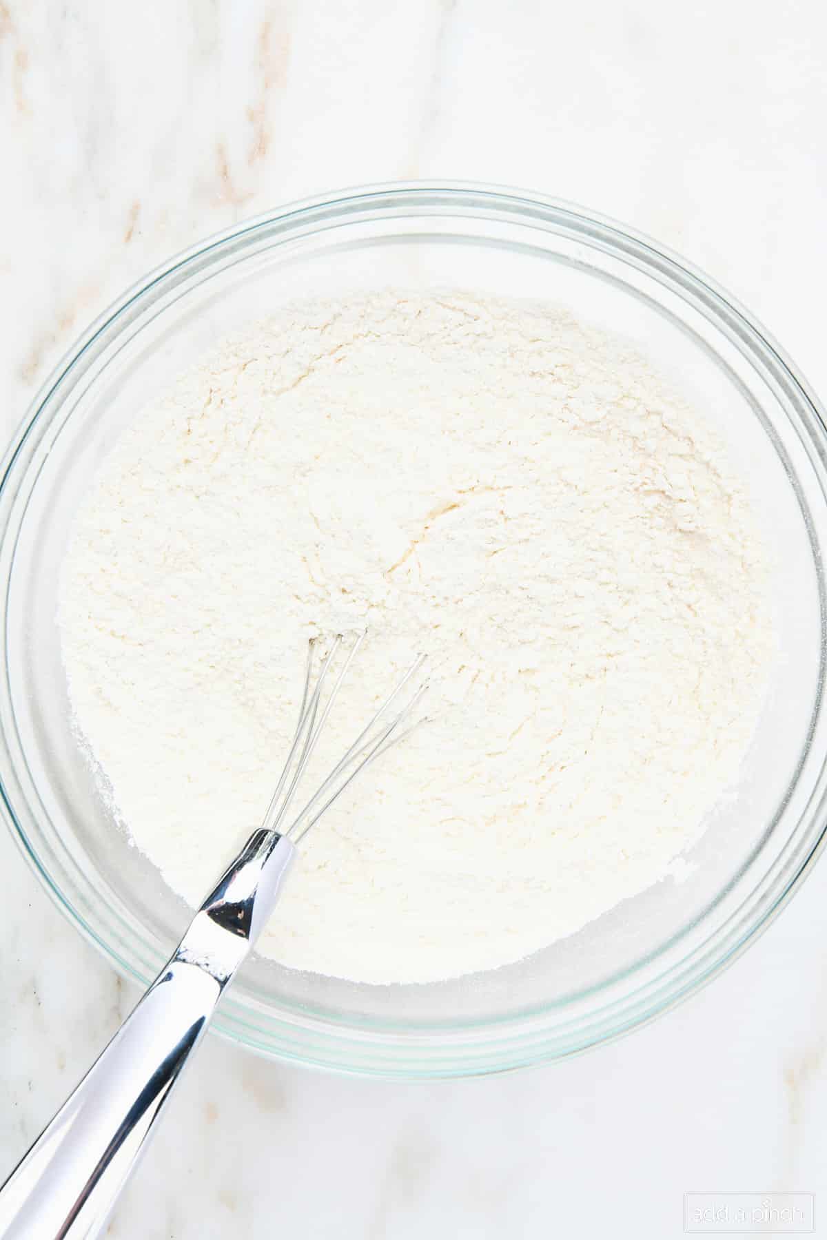 Dry ingredients whisked together in a glass bowl.