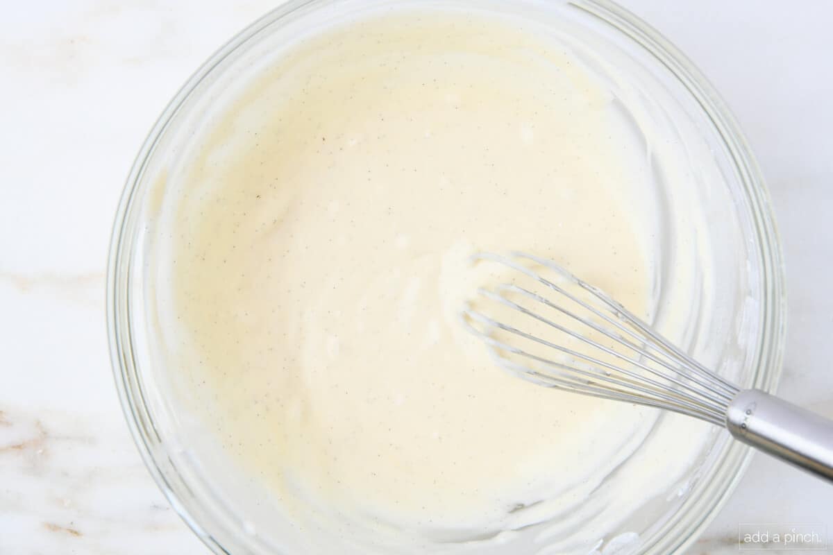 Whisked together vanilla glaze in a glass bowl.