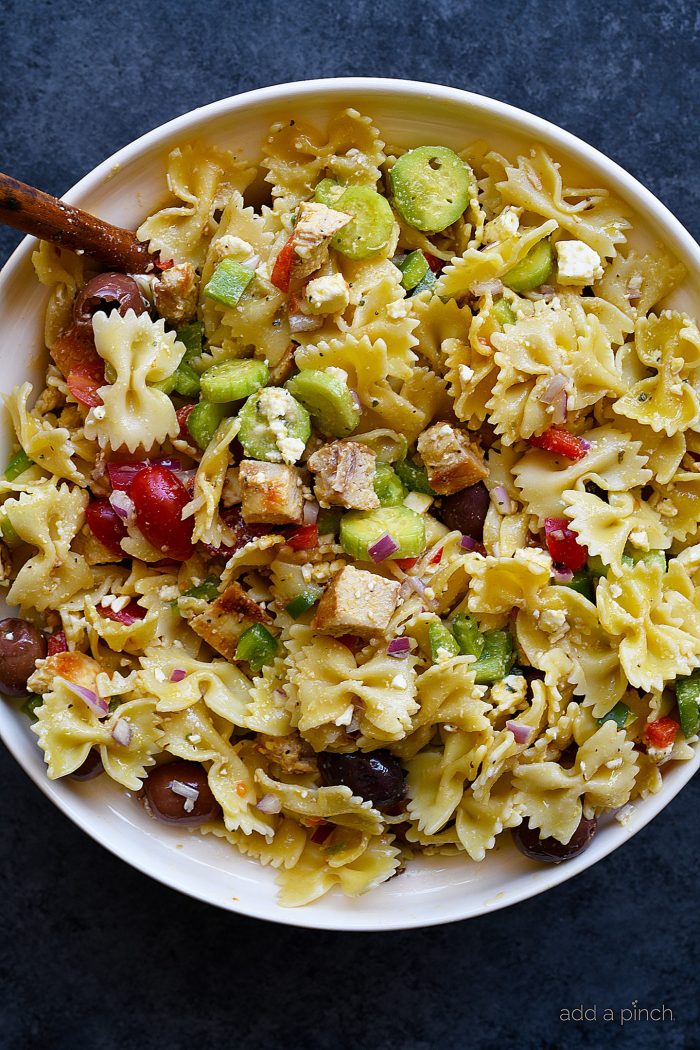 White serving bowl filled with Greek Chicken Pasta Salad 