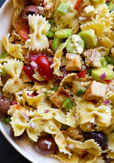 Greek Chicken Pasta Salad Recipe - This easy pasta salad recipe is so easy and delicious! Made with grilled chicken, pasta, an assortment of vegetables and topped with feta cheese and a delicious Greek dressing!  // addapinch.com