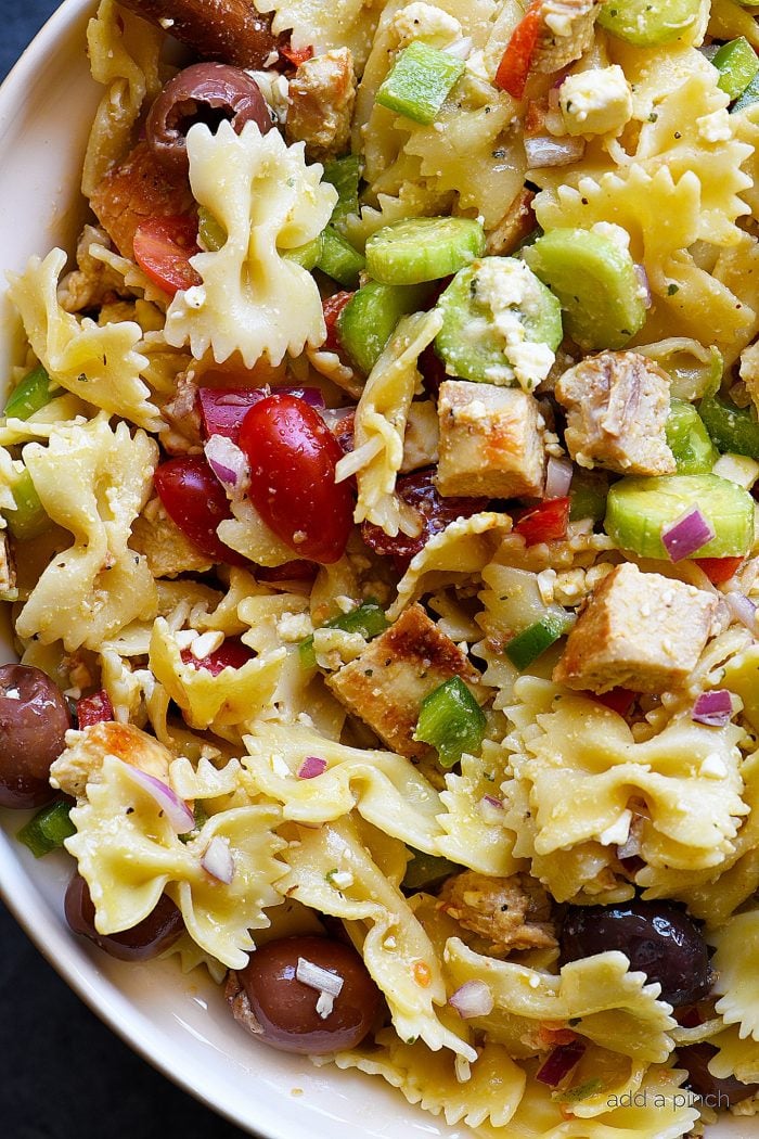 Greek Chicken Pasta Salad Recipe - This easy pasta salad recipe is so easy and delicious! Made with grilled chicken, pasta, an assortment of vegetables and topped with feta cheese and a delicious Greek dressing!Â  // addapinch.com