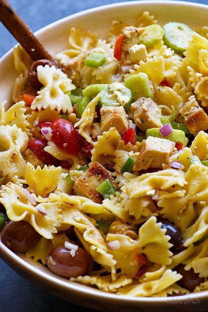 Greek Chicken Pasta Salad Recipe - This easy pasta salad recipe is so easy and delicious! Made with grilled chicken, pasta, an assortment of vegetables and topped with feta cheese and a delicious Greek dressing!  // addapinch.com