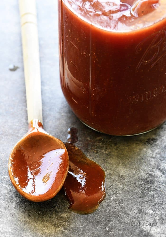 Homemade BBQ Sauce Recipe in a mason jar with a wooden spoon on the side.