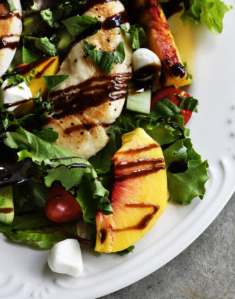 Grilled Chicken and Peach Salad Recipe - A light and delicious dish that is perfect for lunch or dinner. Made with grilled chicken, fresh juicy peaches, and topped with tangy balsamic. // addapinch.com