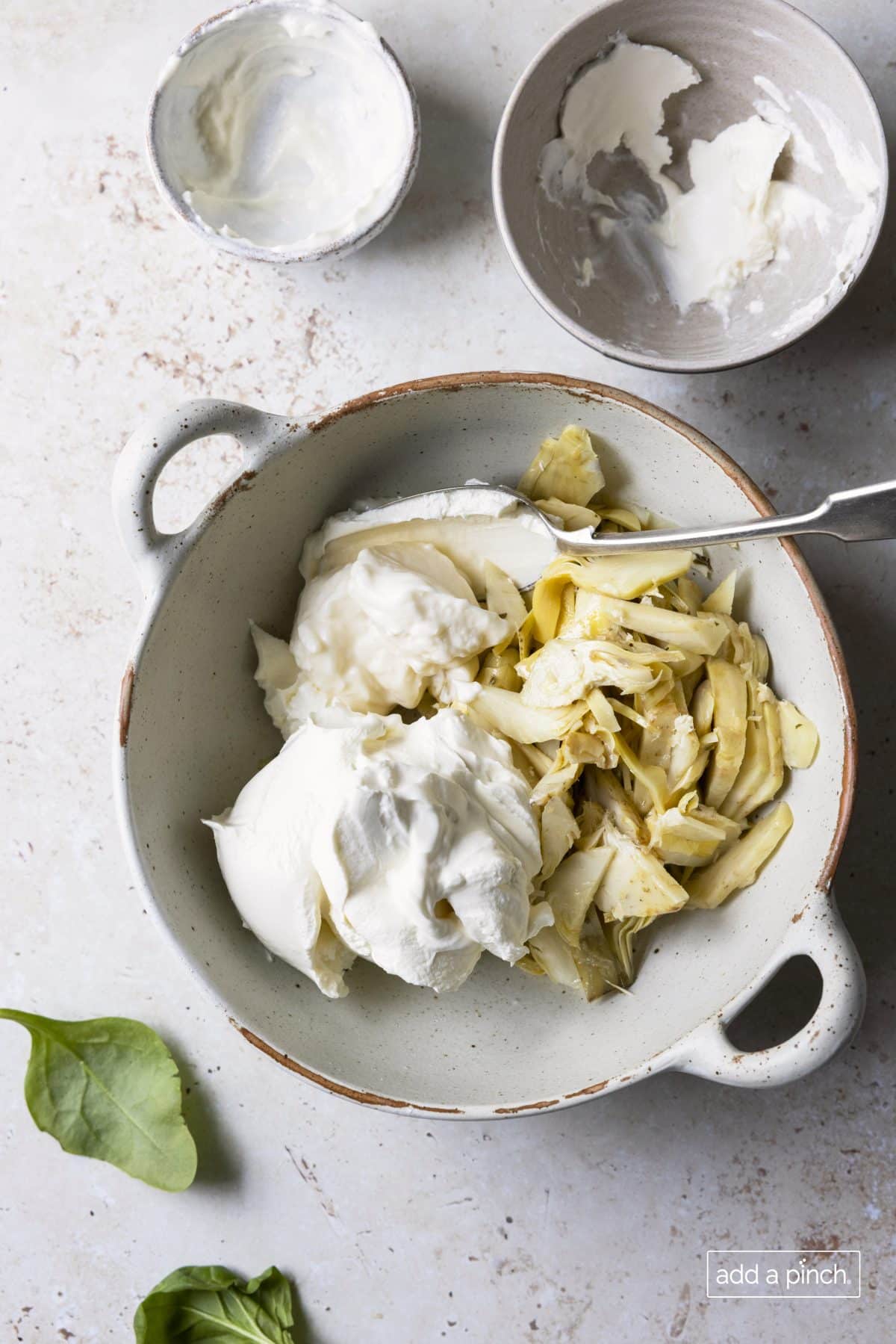Photograph of artichoke hearts and the creamy ingredients for the dip recipe.