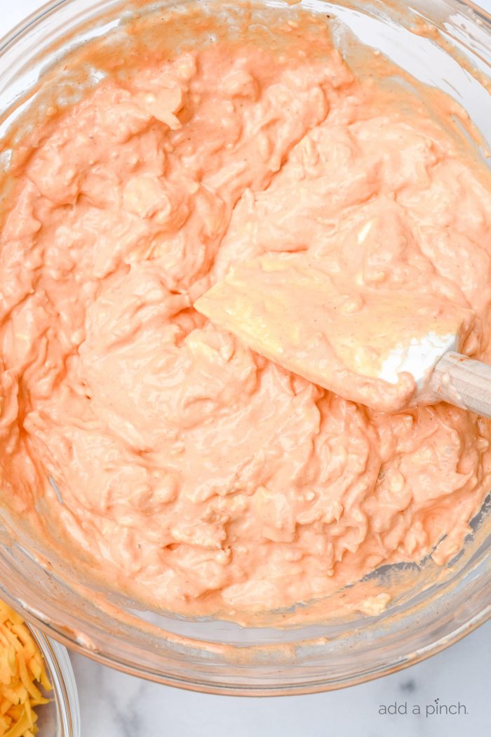 Buffalo Chicken Dip tastes like the buffalo chicken wings we love but without the mess! This easy appetizer is made with just a handful of ingredients in the oven or slow cooker! // addapinch.com