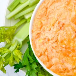 Buffalo Chicken Dip tastes like the buffalo chicken wings we love but without the mess! This easy appetizer is made with just a handful of ingredients in the oven or slow cooker! // addapinch.com