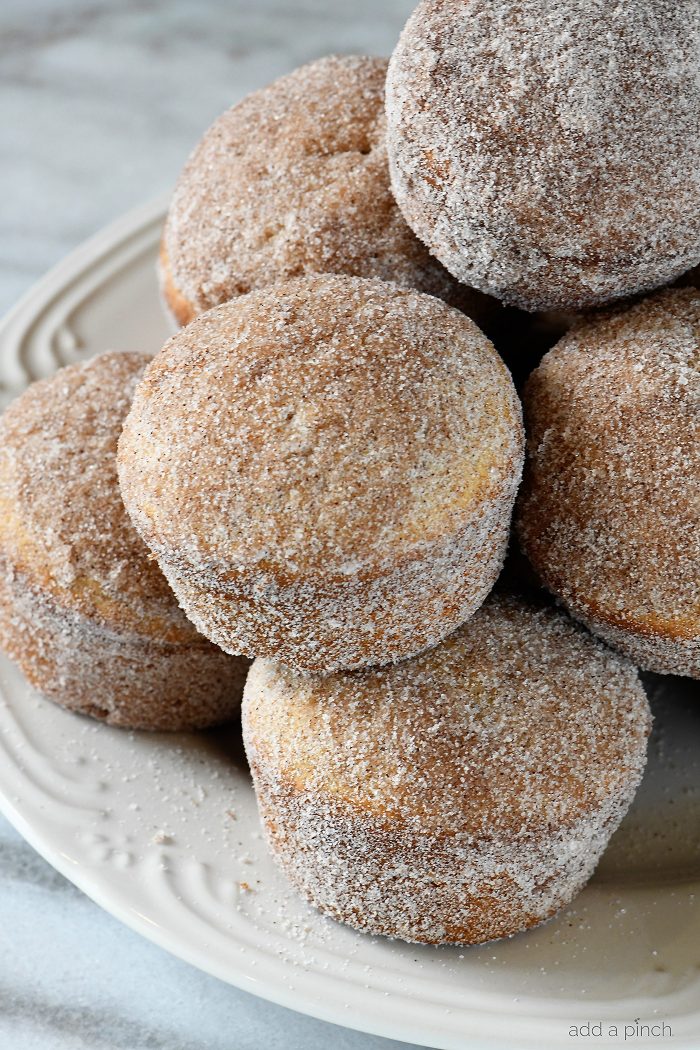 Apple Cider Donut Muffins Recipe - These apple cider muffins are light, fluffy and coated in an amazing cinnamon sugar coating! // addapinch.com