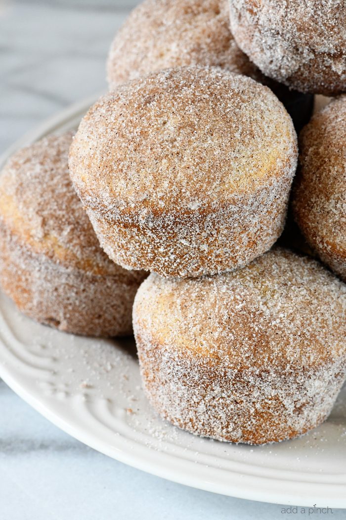 Apple Cider Donut Muffins Recipe - These apple cider muffins are light, fluffy and coated in an amazing cinnamon sugar coating! // addapinch.com