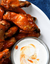 Baked Crispy Buffalo Chicken Wings Recipe - Crispy buffalo wings no longer have to be deep fried to be delicious! This easy recipe for baked chicken wings makes everyone's favorite wing even better! // addapinch.com